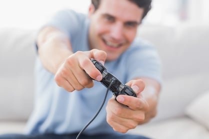 Portrait of a smiling man playing video games in his living room